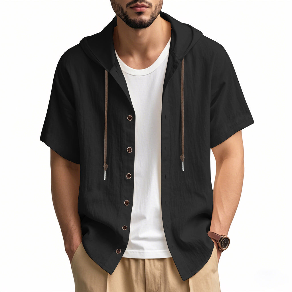 Man wearing a black short-sleeve button-up shirt over a white t-shirt on a white background