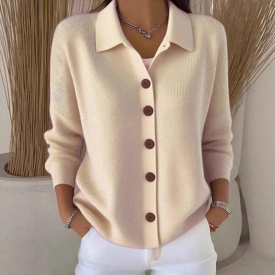 Beige cardigan with brown buttons worn by a person, against a neutral background
