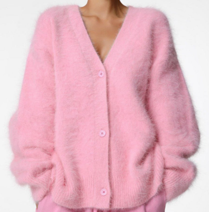 Pink cardigan worn by a person on a white background