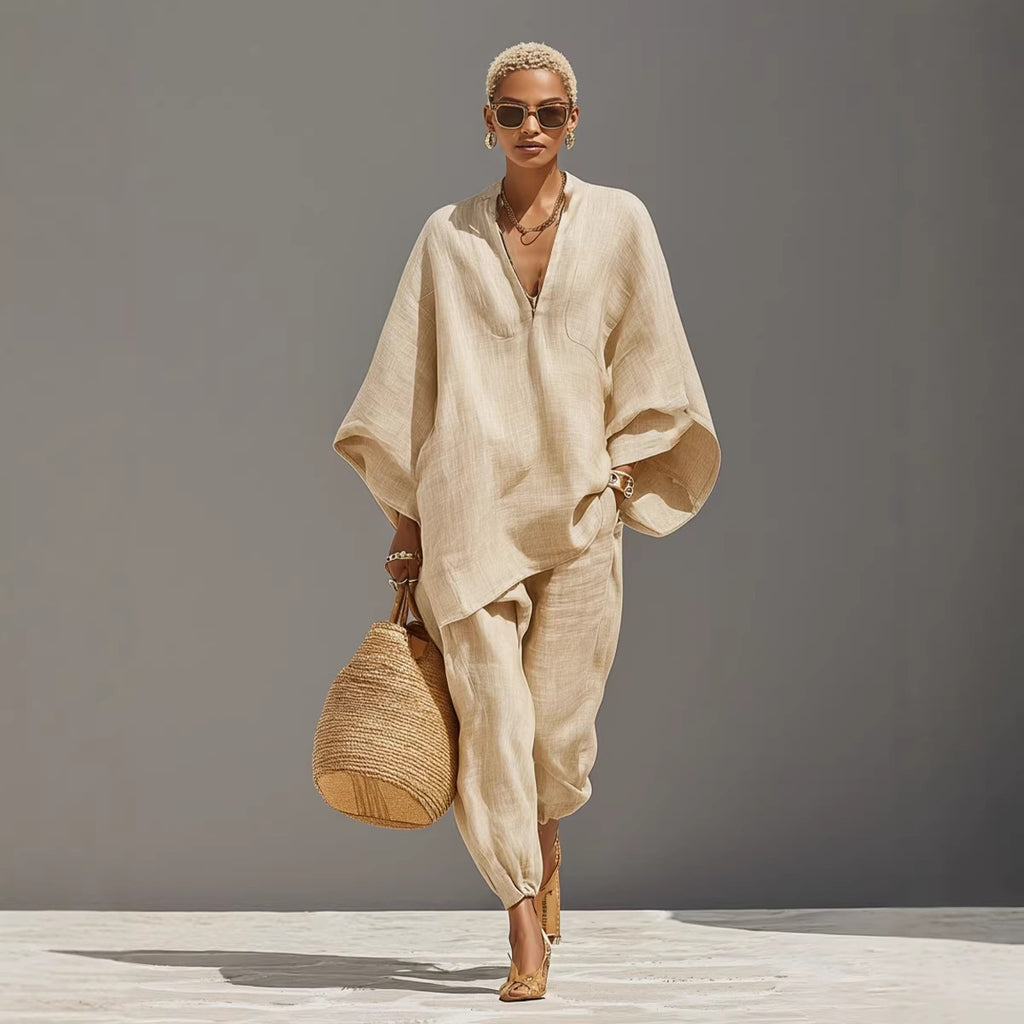 Woman in a beige outfit holding a woven bag against a gray background