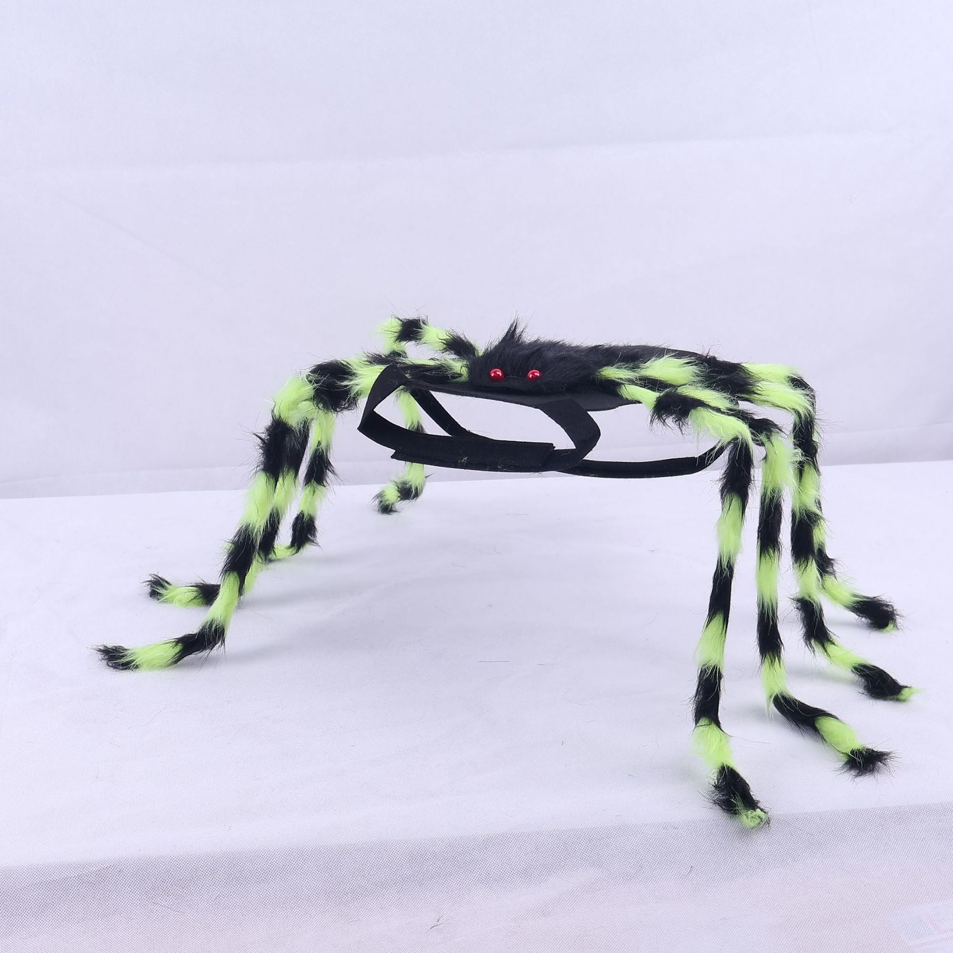 Toy spider with glowing green legs on a white background