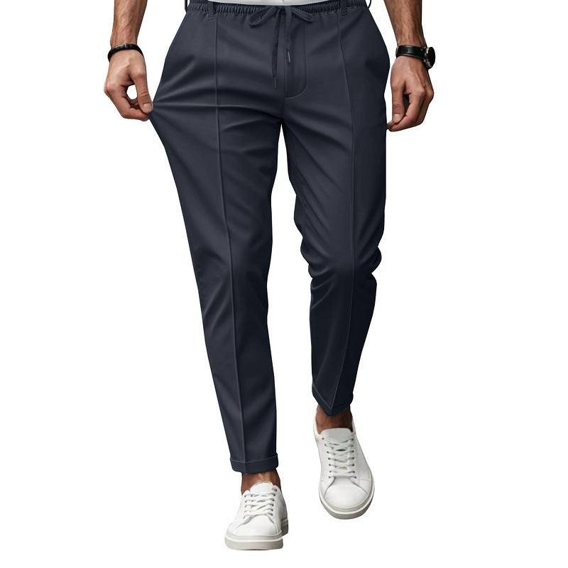 Dark gray jogger pants worn by a person on a white background