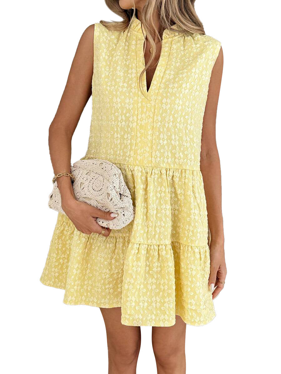 Woman wearing a yellow floral dress holding a clutch on a white background