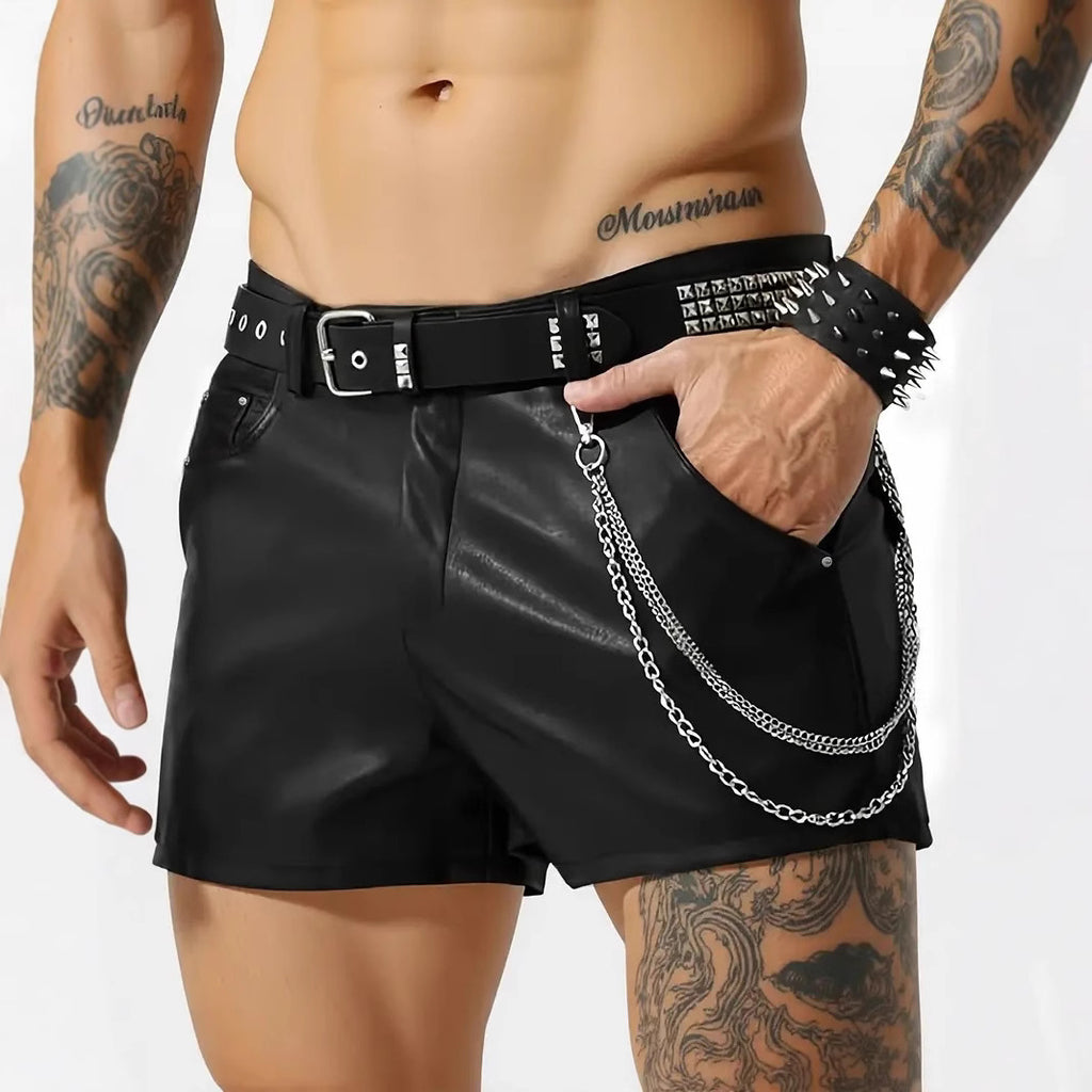 Person wearing black leather shorts with chain detail on a white background