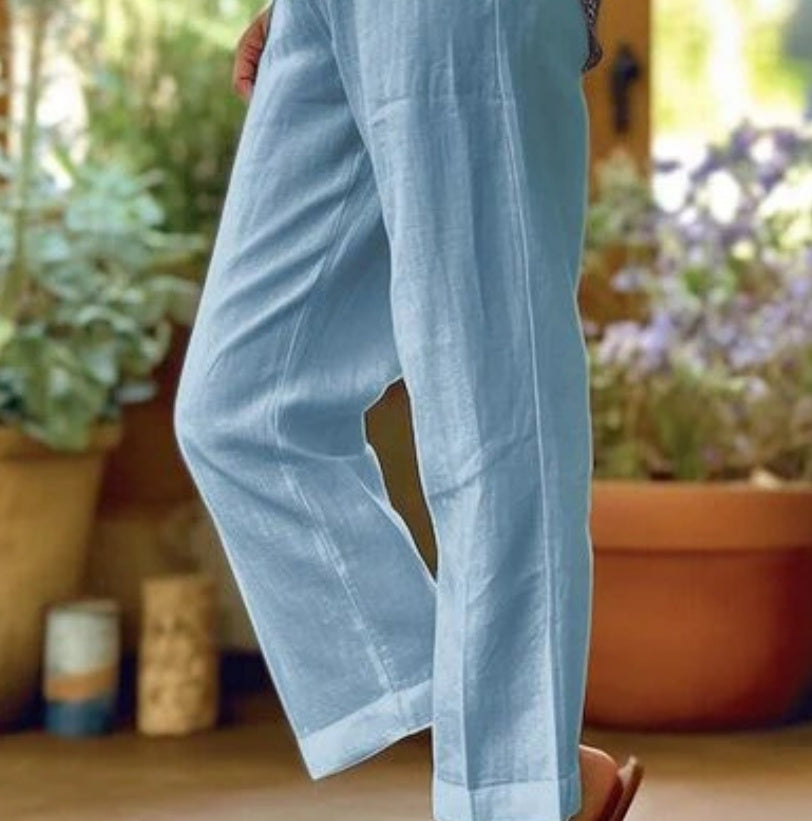 Light blue pants being worn with a blurred background of plants and pots