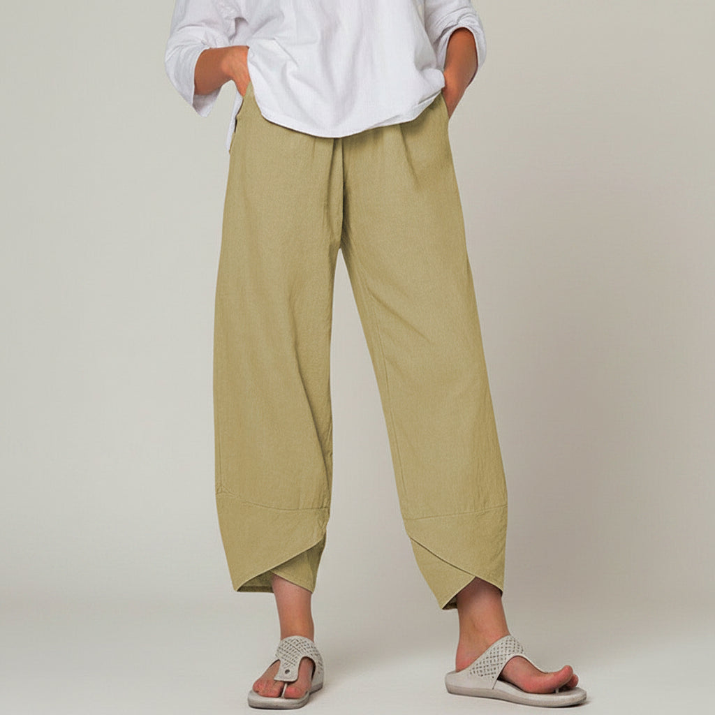 Person wearing beige wide-leg pants and a white shirt on a white background