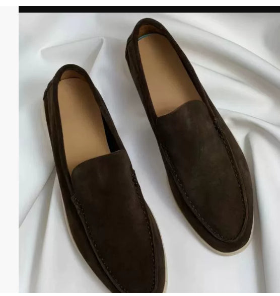 Pair of brown loafers on a white fabric background