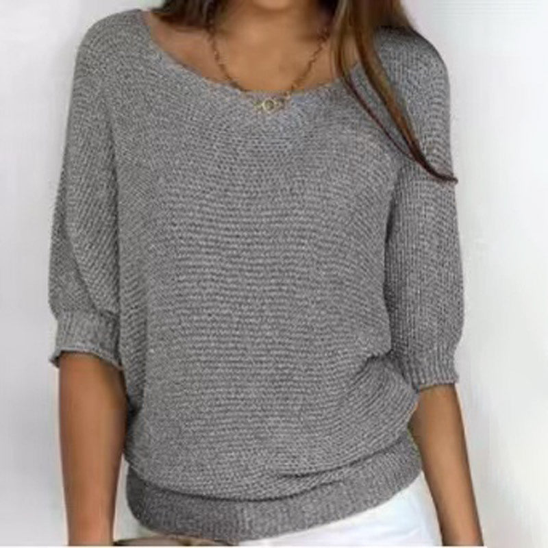 Gray knitted sweater worn by a person on a white background