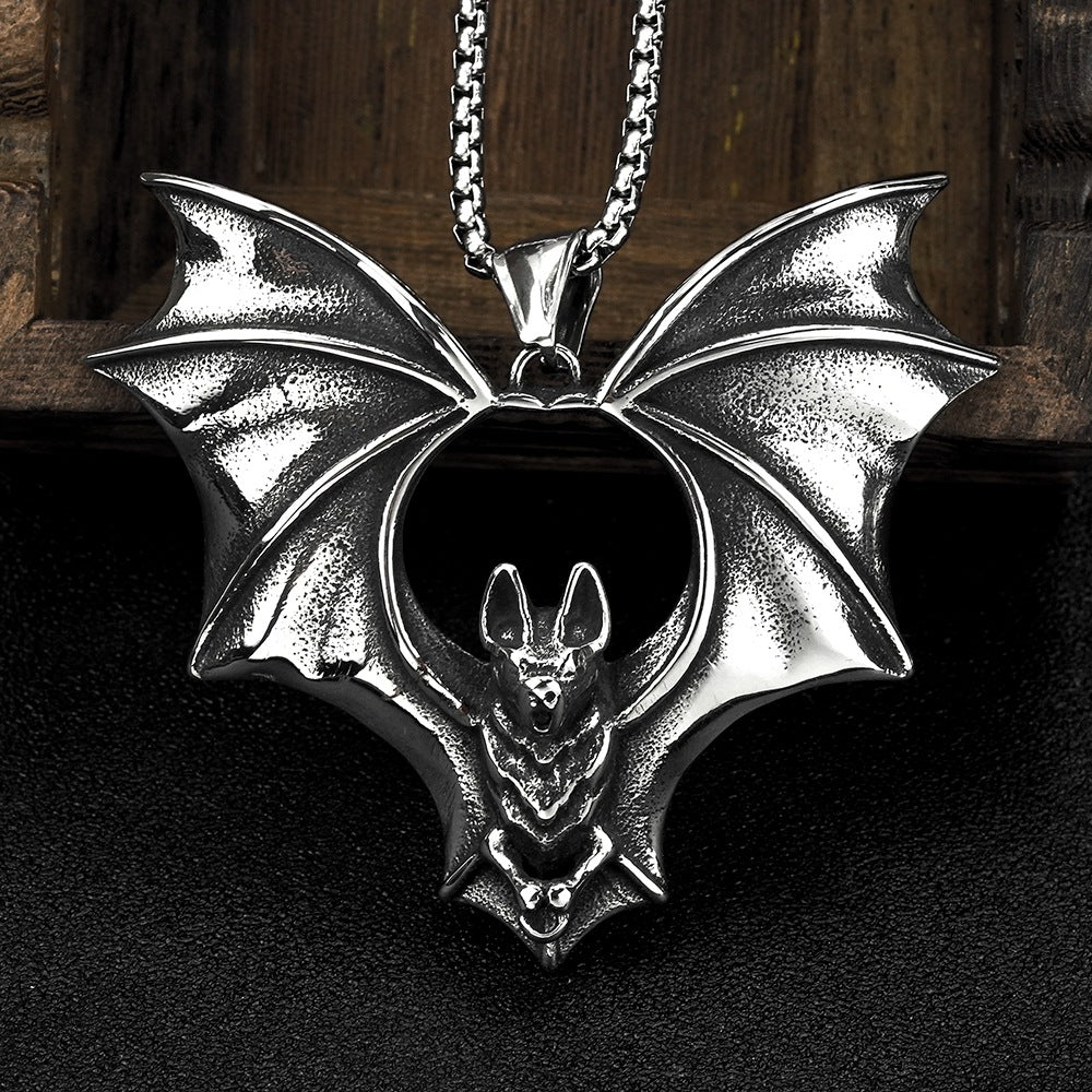 Silver bat-shaped pendant on a chain against a dark background
