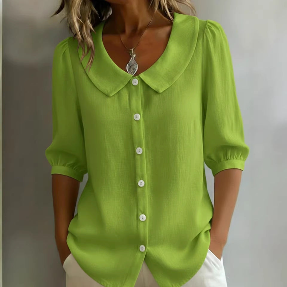 Green blouse with a collar worn by a person on a plain background