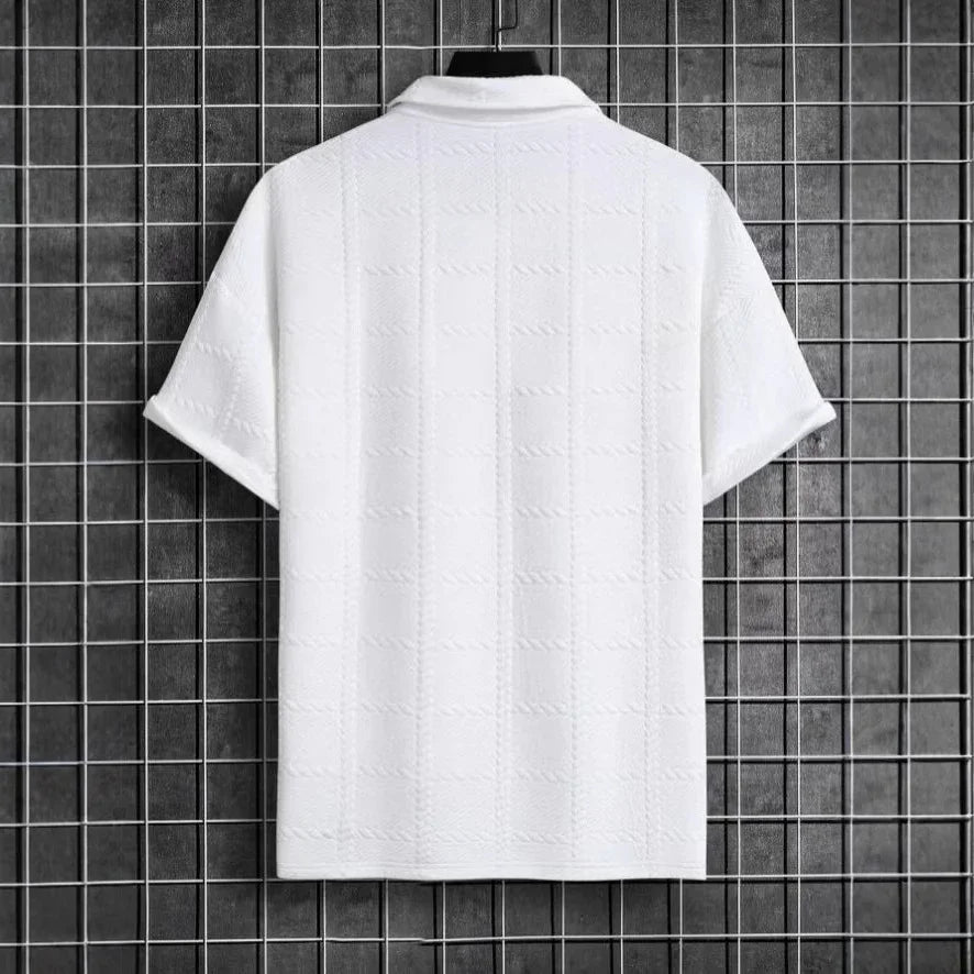 White textured shirt on a mannequin against a black tiled wall