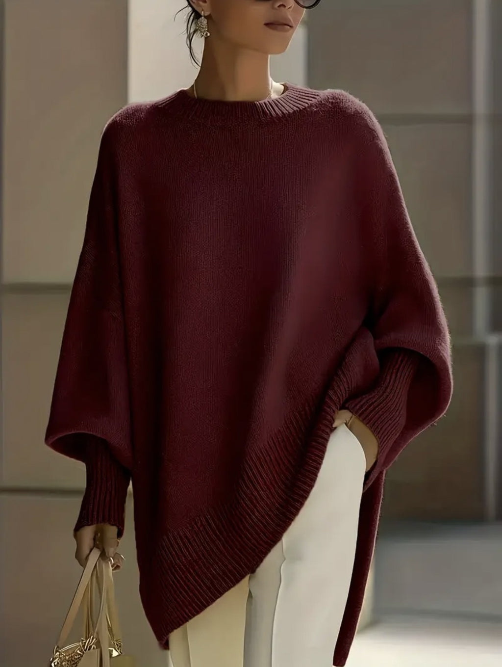 Person wearing a burgundy poncho in an indoor setting