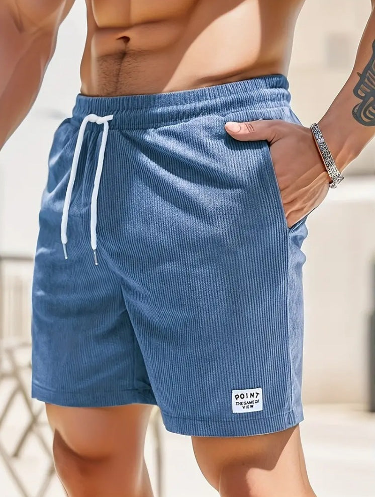 Blue shorts with a brand logo worn by a person, blurred background