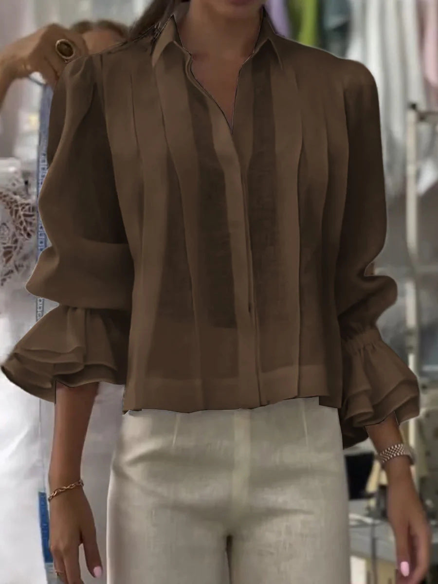Brown blouse with ruffled sleeves worn by a person, blurred background