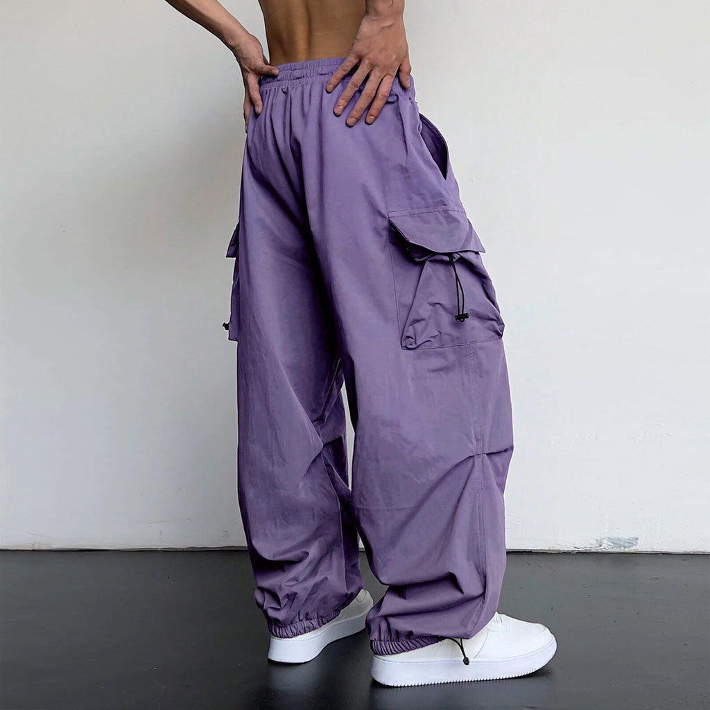 Person wearing purple cargo pants with a plain background