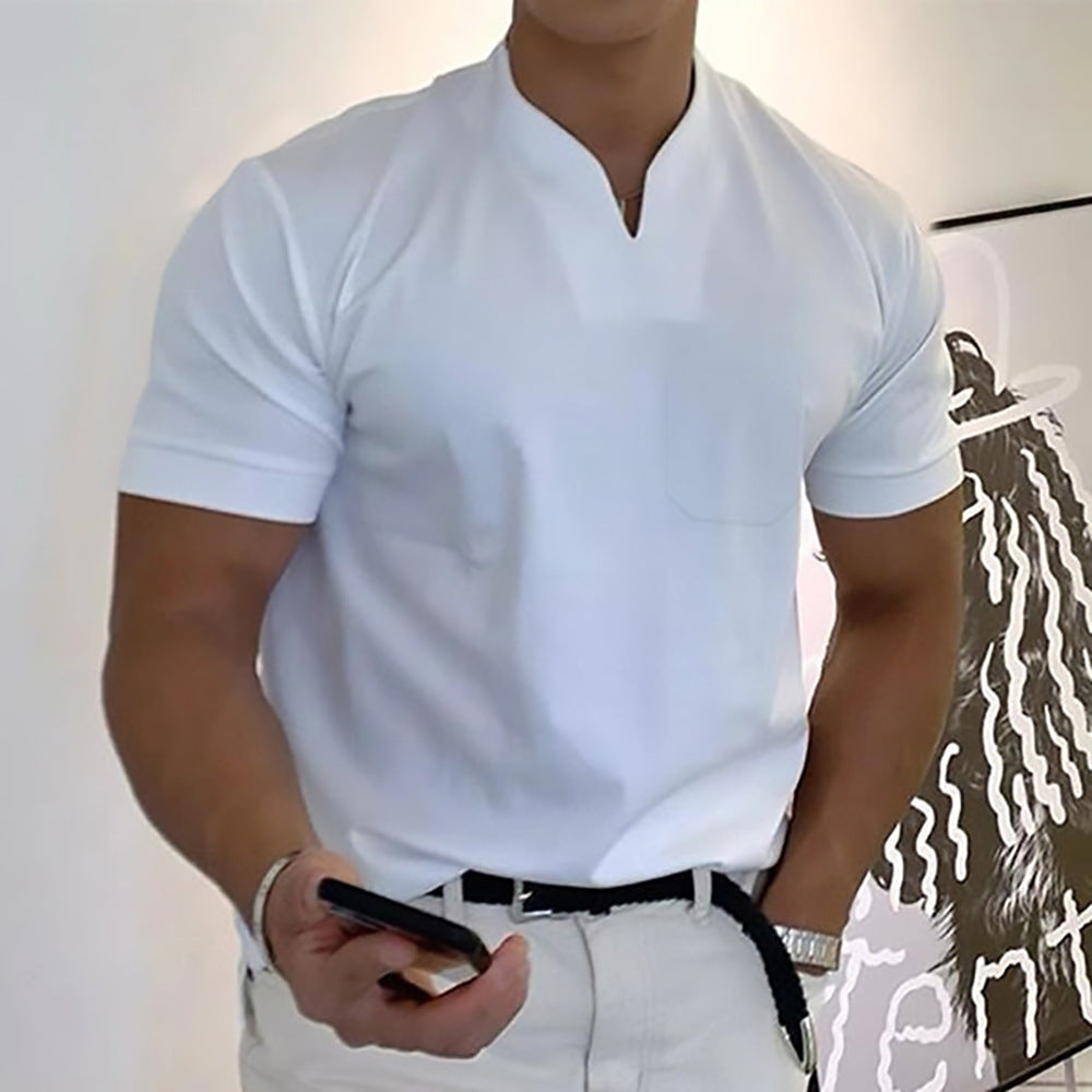 Person wearing a white polo shirt and pants, holding a phone.
