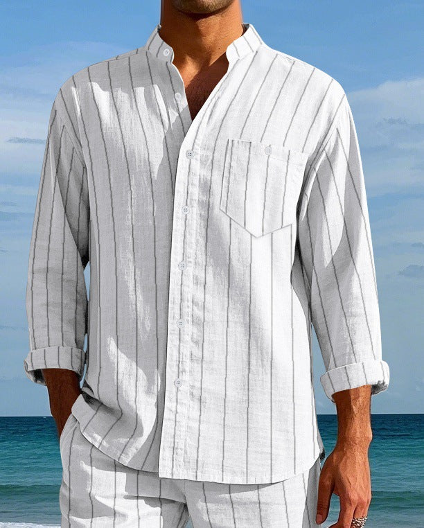 Person wearing a white and gray striped shirt and pants on a beach.