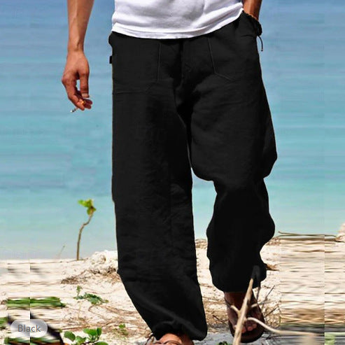 Person wearing black pants and a white shirt by a body of water.