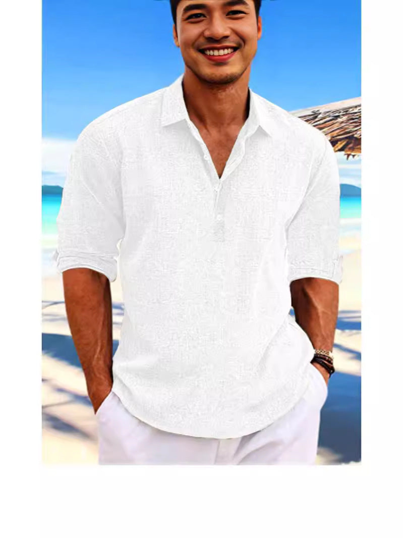 Man wearing a white shirt on a beach with clear blue sky
