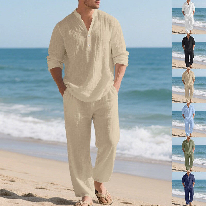 Man wearing a beige linen outfit on a beach with ocean waves in the background.