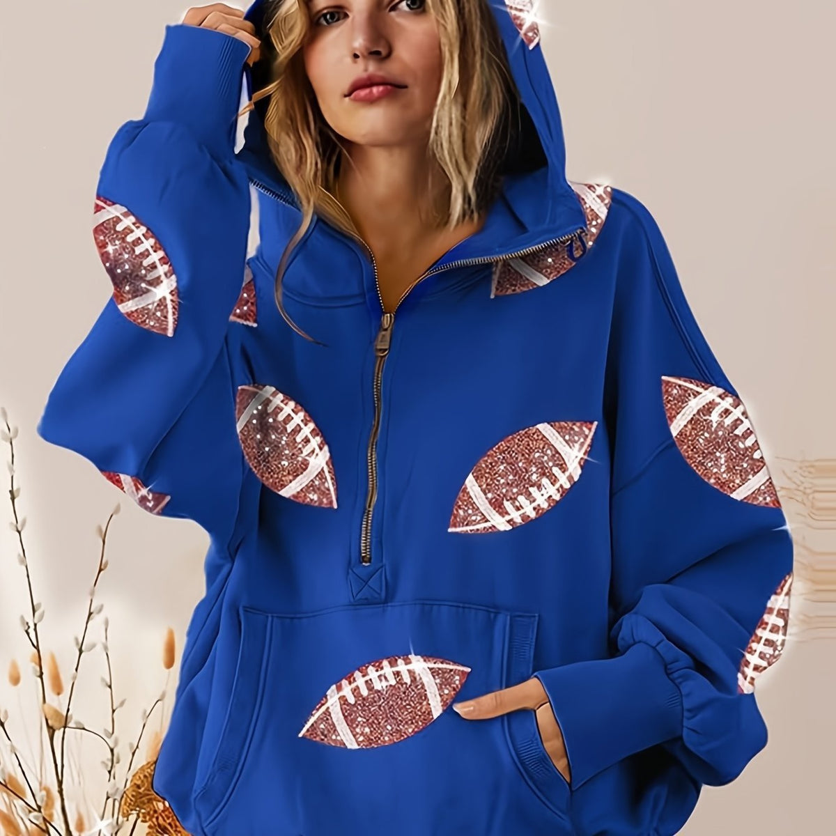 Blue hoodie with football designs on a neutral background