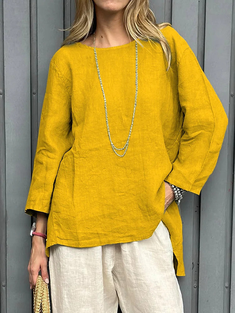 Person wearing a mustard yellow top and white pants against a gray background