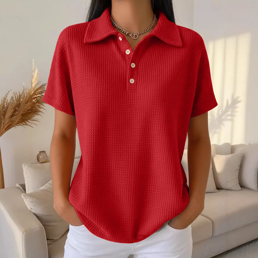 Person wearing a red textured polo shirt in a living room setting