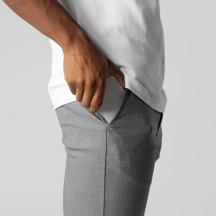 Person wearing a white shirt and gray pants on a light gray background
