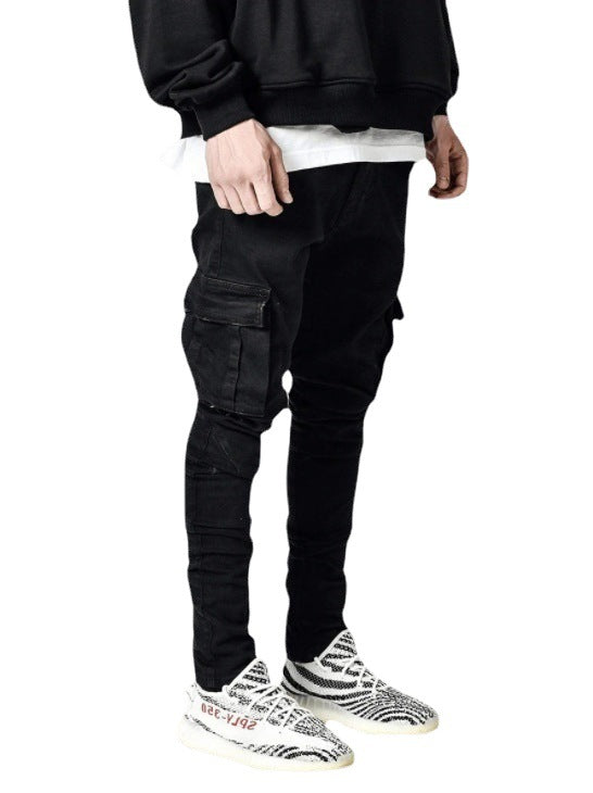 Person wearing black cargo pants and zebra-striped shoes on a white background