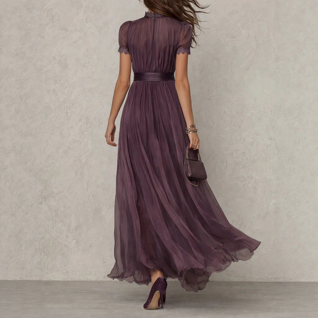 Woman wearing a long purple dress against a neutral background