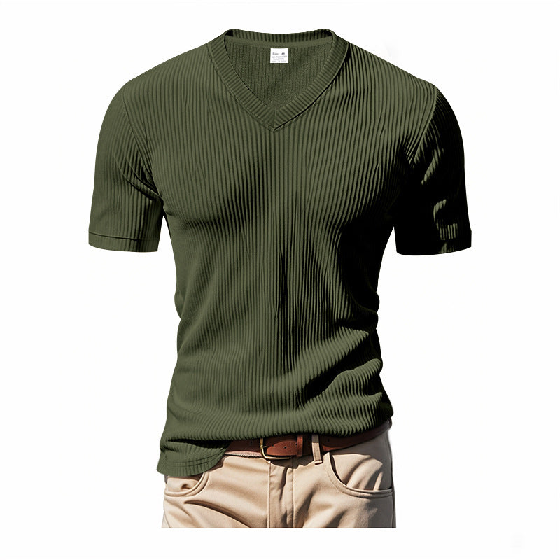 Green ribbed t-shirt worn with beige pants on a white background