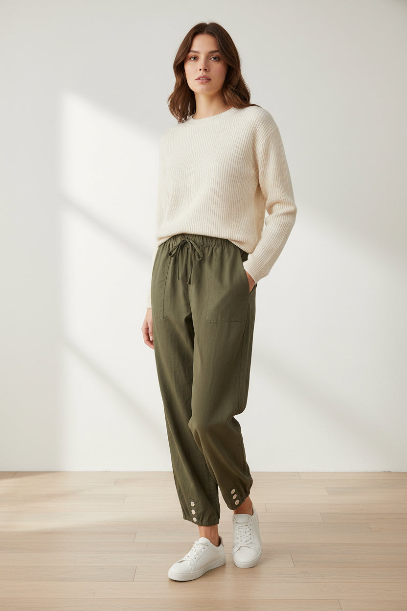 Green cargo pants with button details worn by models on a light wooden floor