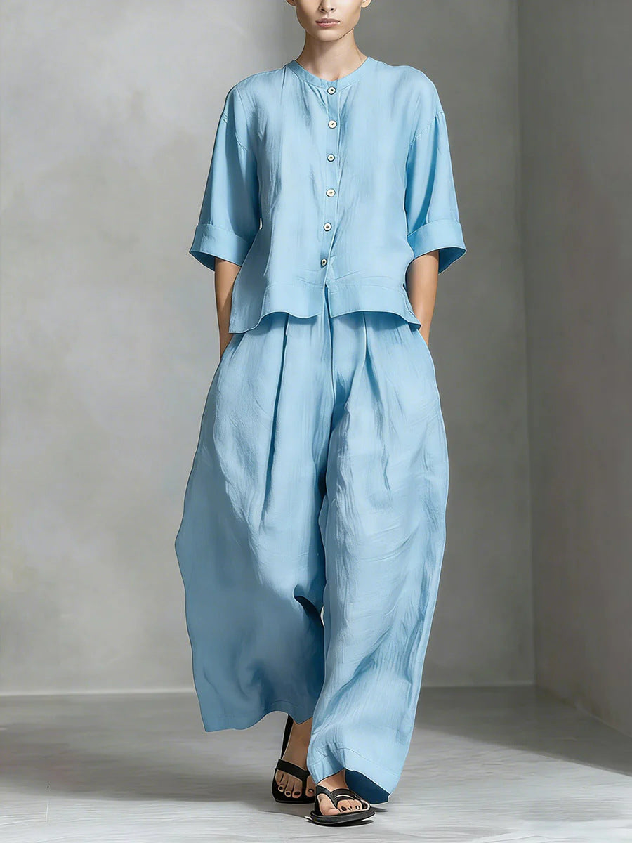 Person wearing a light blue outfit with a plain background