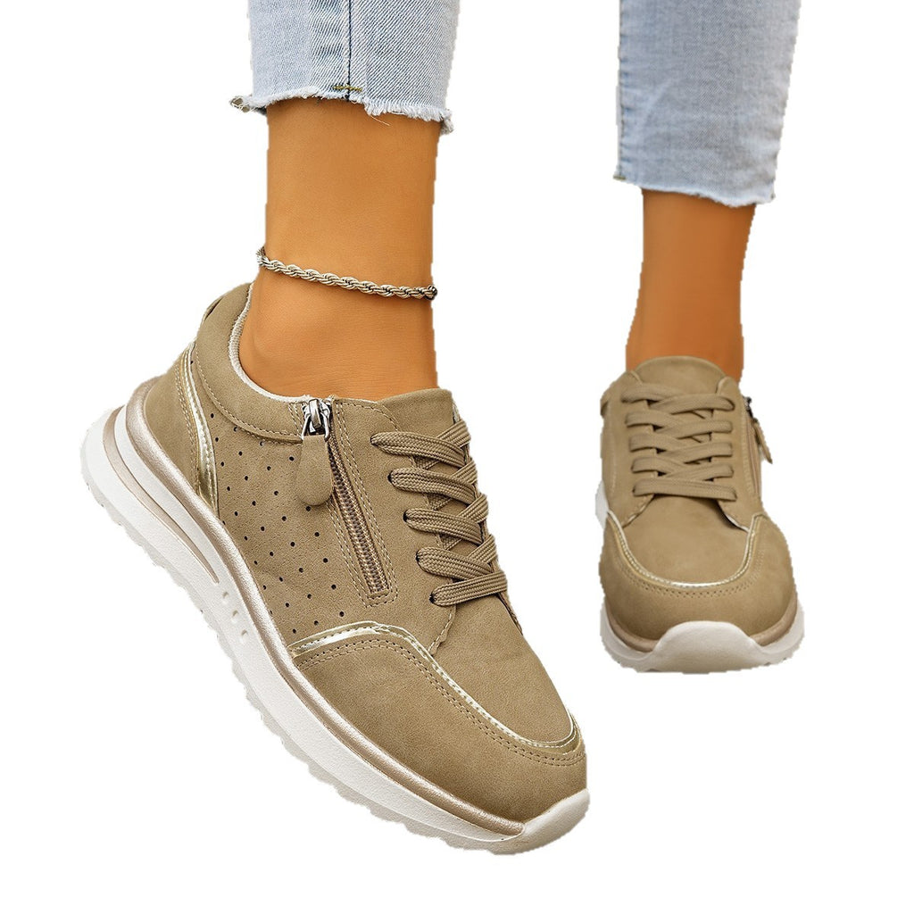 Beige sneakers worn with light blue jeans on a white background