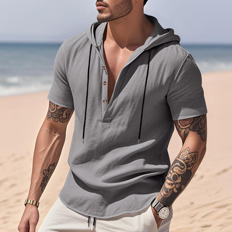 Man wearing a gray hoodie with a beach in the background