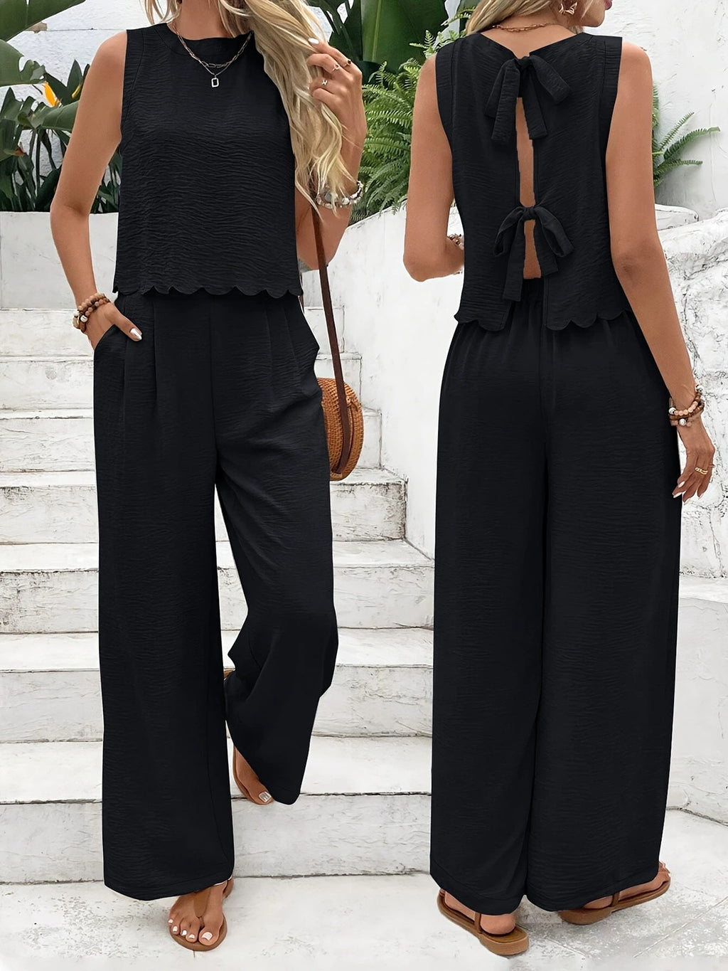 Black sleeveless top and wide-leg pants worn by a person on white steps.
