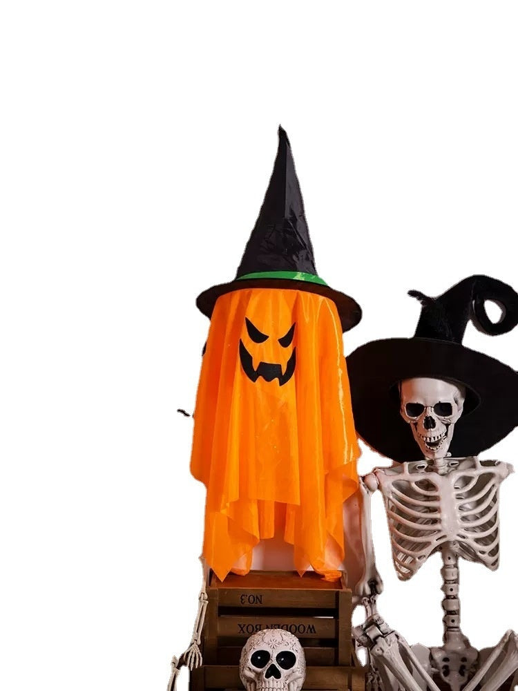 Halloween-themed decoration with a ghost in an orange cape and a skeleton wearing a witch hat on a white background.