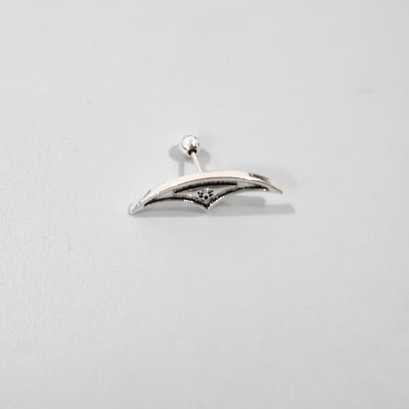 Silver earring on a light gray background