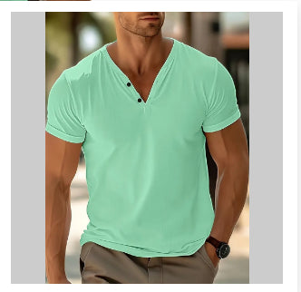 Man wearing a light green V-neck shirt with a blurred background