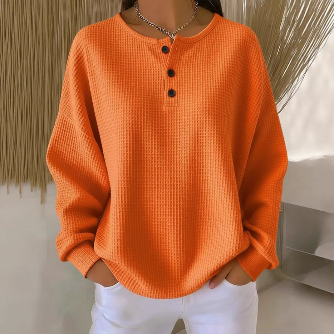 Orange textured sweater worn by a person with a neutral background