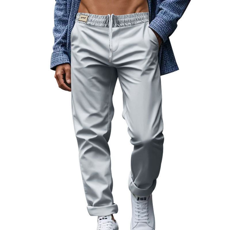 Person wearing light gray jogger pants with a blue jacket on a white background