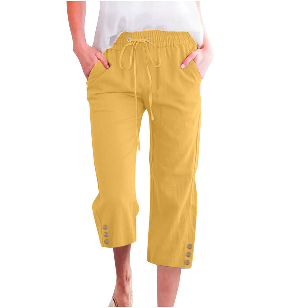 Yellow capri pants with buttons on a white background