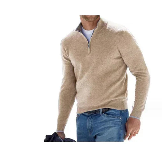 Man wearing a beige sweater and blue jeans on a white background
