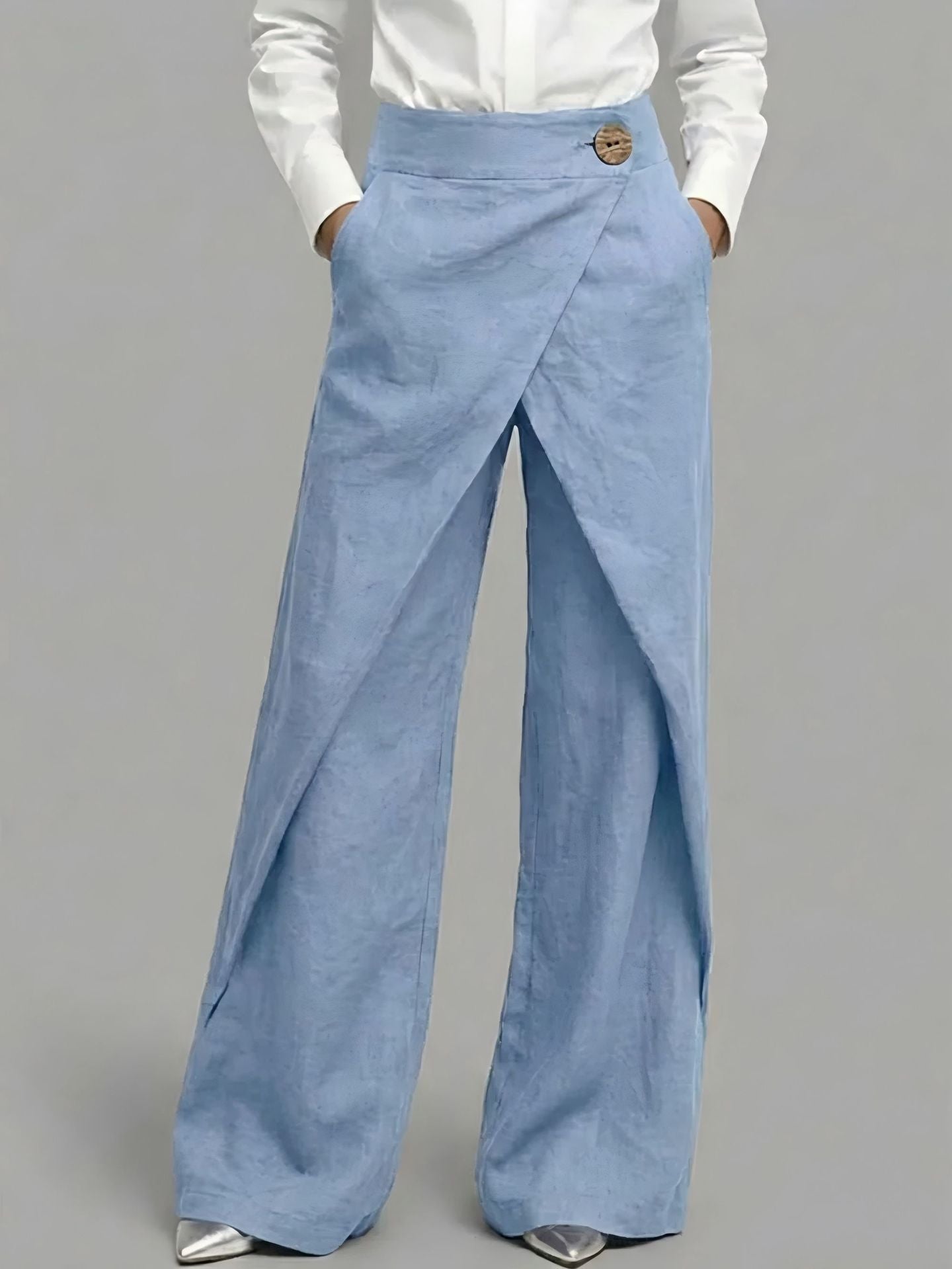 Light blue wide-leg pants worn with a white shirt on a gray background