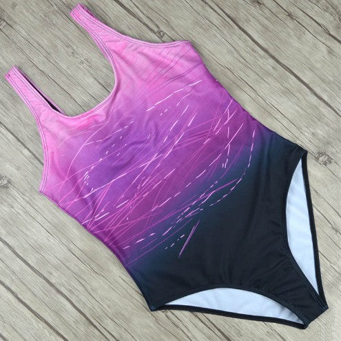 One-piece swimsuit with purple and black gradient on a wooden floor