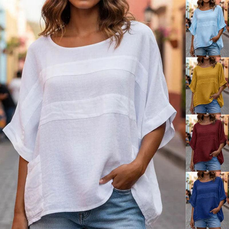 Woman wearing a white oversized top with side panels in various colors.