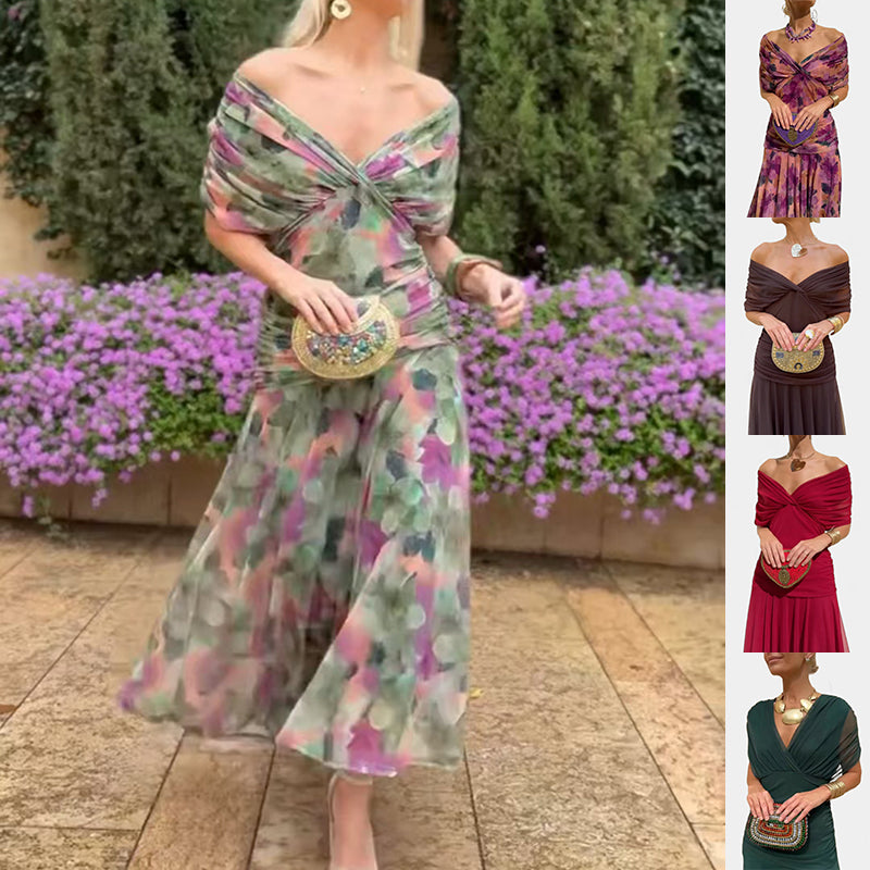 Woman wearing a floral dress with a blurred background of flowers and pavement.