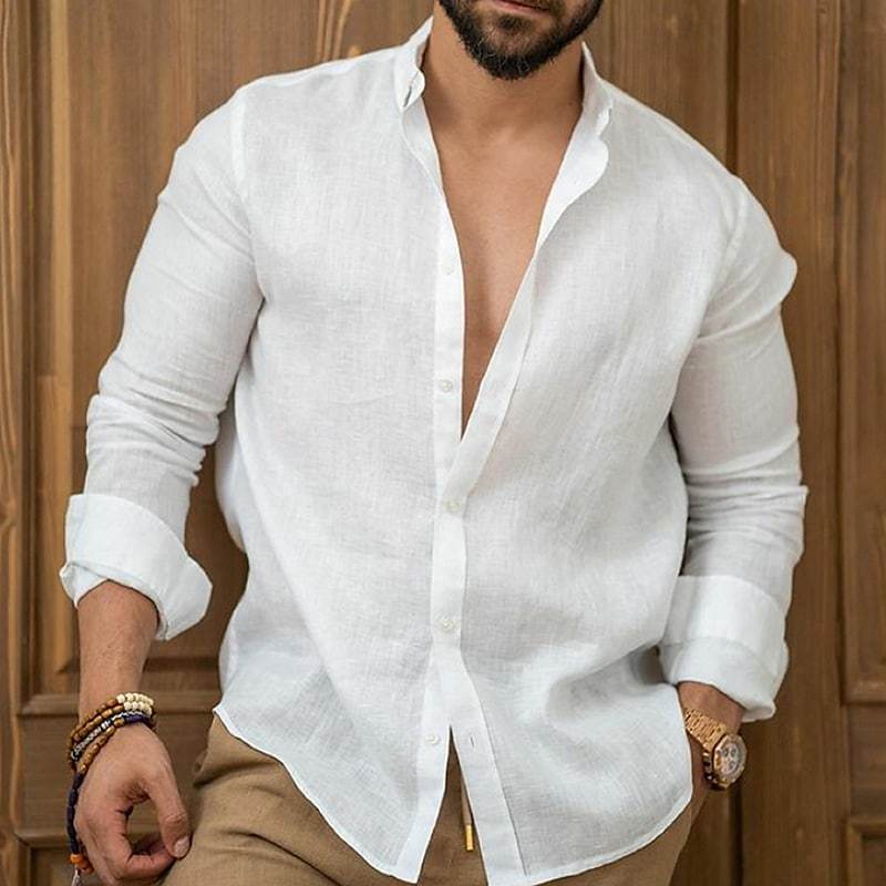 Man wearing a white linen shirt with rolled-up sleeves against a wooden background