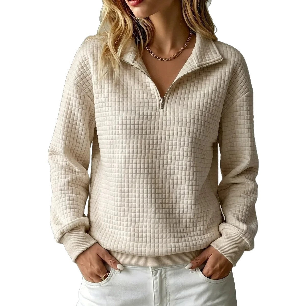 A woman wearing a cream-colored, textured quarter-zip pullover sweater with a stand collar, paired with white pants, shown against a plain white background.