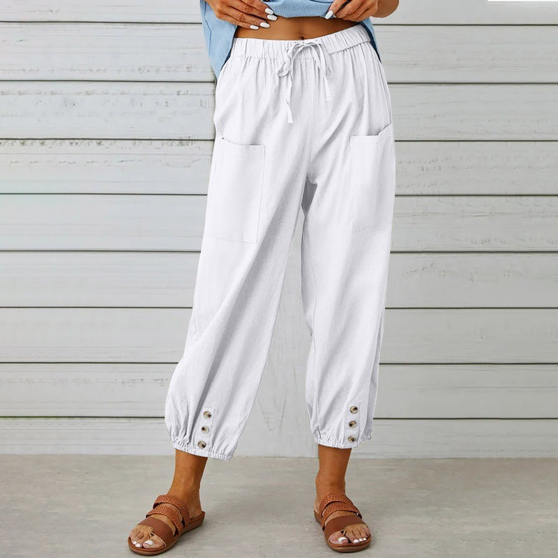 Person wearing white wide-leg pants with a wooden background